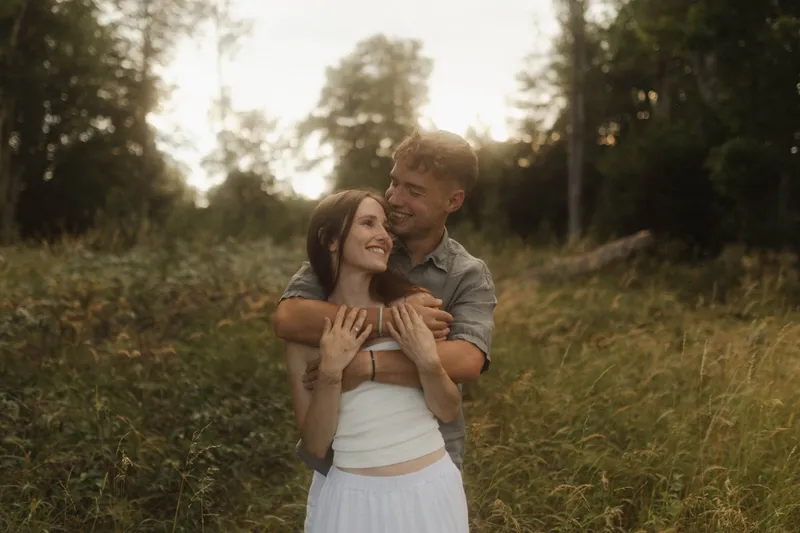 Natalie und Lukas lachen gemeinsam im Grünen