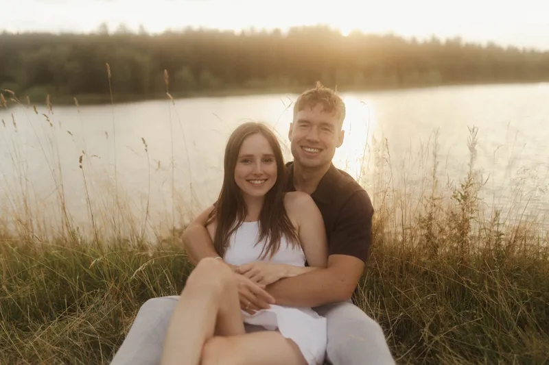 Natalie und Lukas sitzen lachend am See